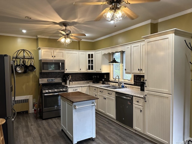 kitchen featuring wood counters, sink, appliances with stainless steel finishes, a kitchen island, and white cabinets