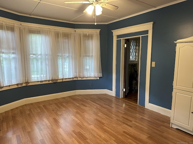 empty room featuring ornamental molding, hardwood / wood-style floors, and ceiling fan