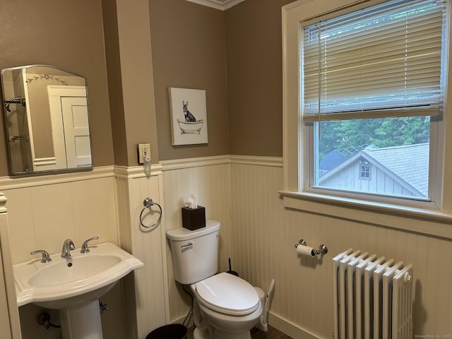 bathroom featuring sink, radiator heating unit, and toilet