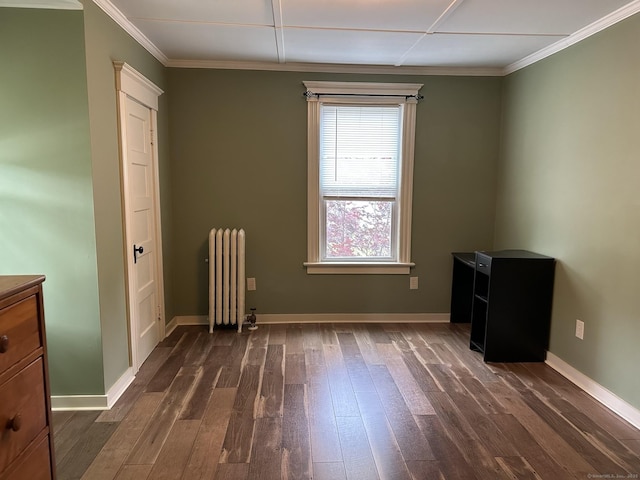 unfurnished room with dark hardwood / wood-style flooring, crown molding, and radiator heating unit