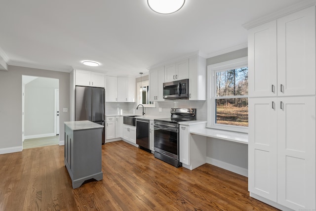 kitchen with a center island, hanging light fixtures, decorative backsplash, white cabinets, and appliances with stainless steel finishes