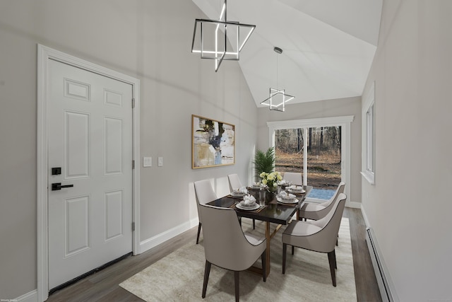 dining space with hardwood / wood-style flooring, high vaulted ceiling, and a baseboard heating unit