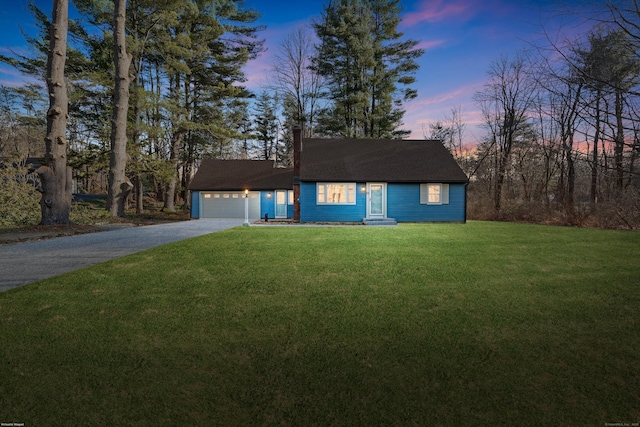 view of front of home with a garage and a yard