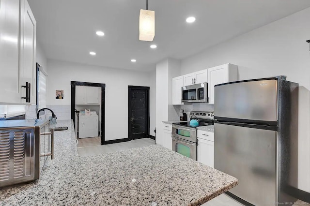 kitchen featuring white cabinets, tasteful backsplash, decorative light fixtures, light stone counters, and stainless steel appliances