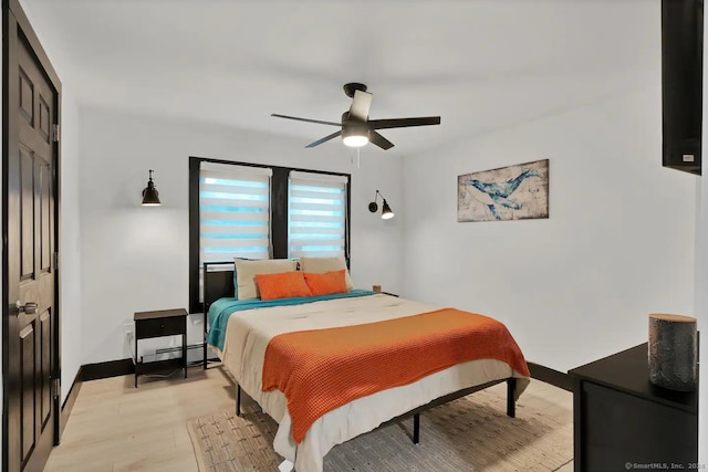 bedroom with ceiling fan, a closet, and light hardwood / wood-style floors