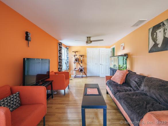 living room featuring hardwood / wood-style floors and ceiling fan