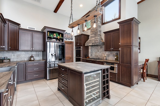 kitchen with a center island, beverage cooler, dark brown cabinets, and appliances with stainless steel finishes