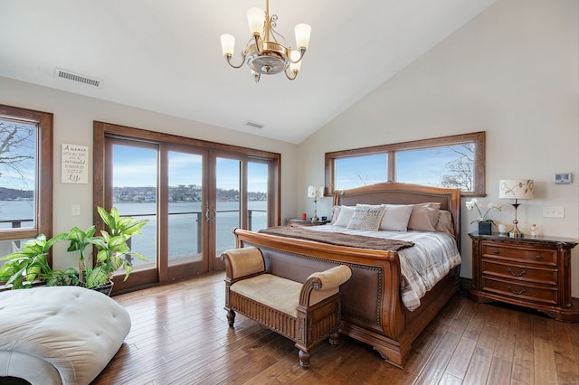 bedroom with hardwood / wood-style flooring, a notable chandelier, a water view, and access to outside