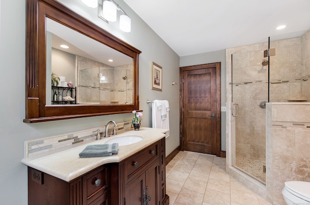 bathroom featuring tile patterned flooring, vanity, toilet, and walk in shower