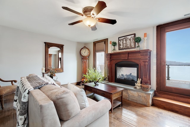 living room with ceiling fan, light hardwood / wood-style floors, and a fireplace