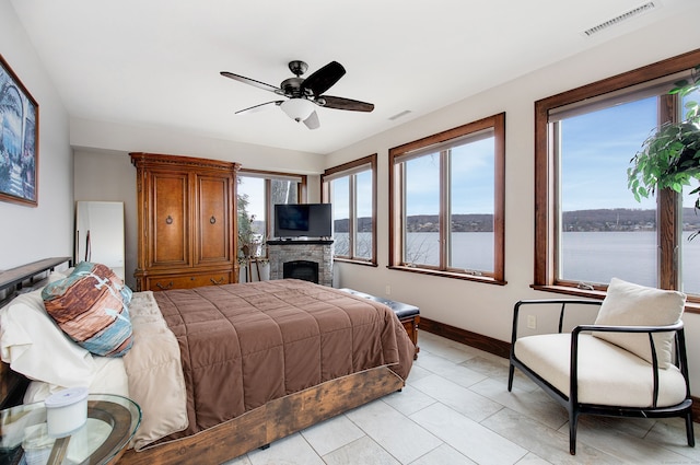 bedroom with ceiling fan and a fireplace