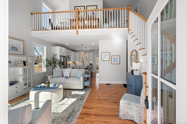 living room featuring light hardwood / wood-style floors and a towering ceiling