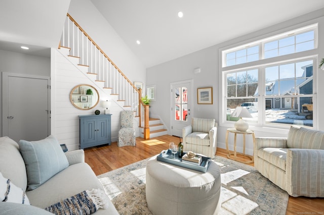 living room featuring high vaulted ceiling and light hardwood / wood-style floors