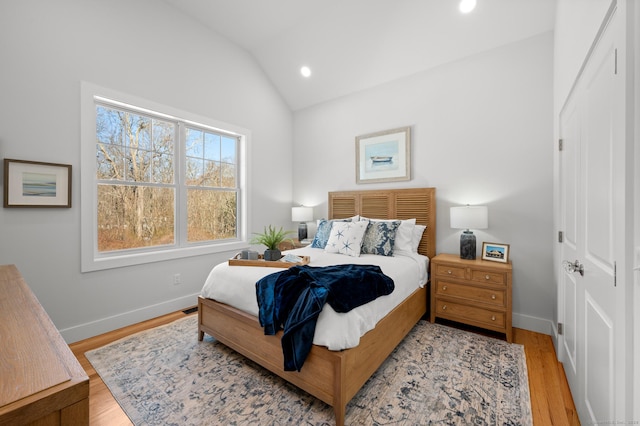 bedroom with light hardwood / wood-style flooring and lofted ceiling