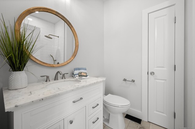 bathroom with tile patterned flooring, vanity, toilet, and walk in shower