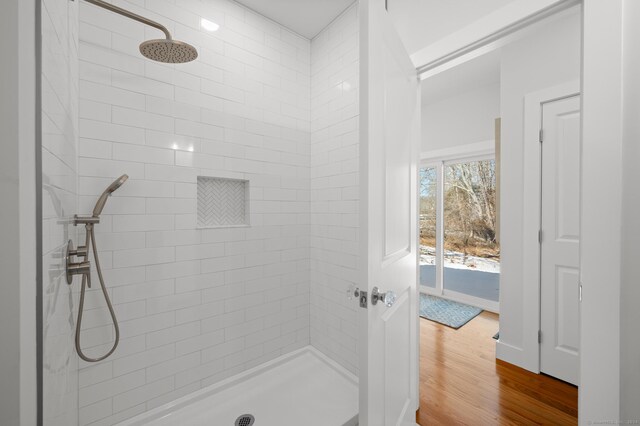 bathroom with wood-type flooring and tiled shower