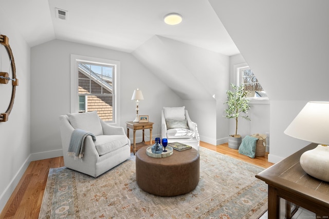 sitting room with hardwood / wood-style floors, a wealth of natural light, and lofted ceiling