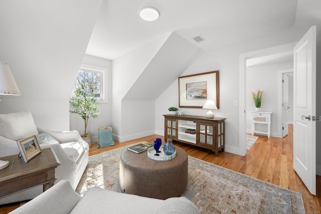 living room featuring lofted ceiling and light wood-type flooring