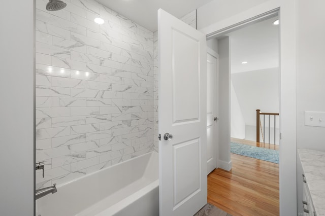 bathroom with vanity, wood-type flooring, and tiled shower / bath combo