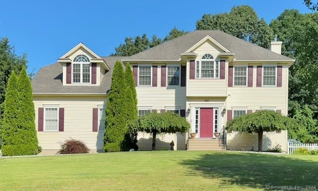 colonial-style house featuring a front yard