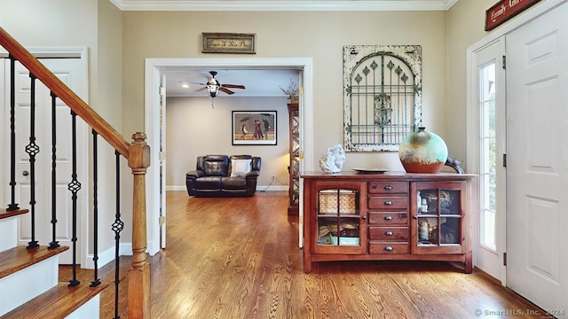 foyer entrance with ceiling fan, ornamental molding, and hardwood / wood-style flooring