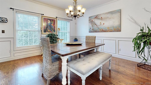 dining room featuring a healthy amount of sunlight, an inviting chandelier, ornamental molding, and wood-type flooring