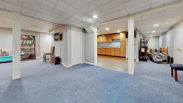 basement with white refrigerator and light colored carpet