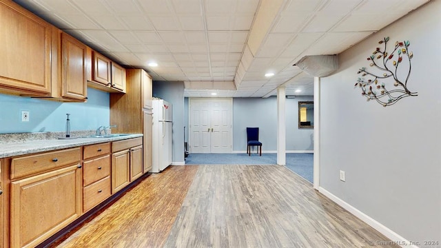 kitchen featuring sink, light wood-type flooring, and white refrigerator