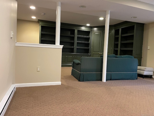 basement featuring built in features, carpet, and a baseboard heating unit