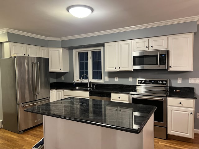 kitchen featuring white cabinets, a center island, stainless steel appliances, and sink