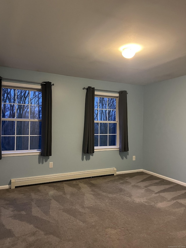 unfurnished room featuring carpet floors and a baseboard heating unit