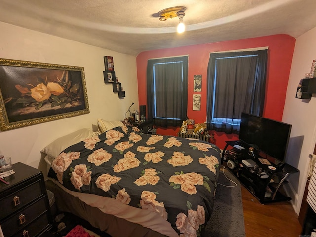 bedroom featuring wood-type flooring and a textured ceiling