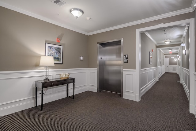 hallway featuring elevator, crown molding, and dark colored carpet