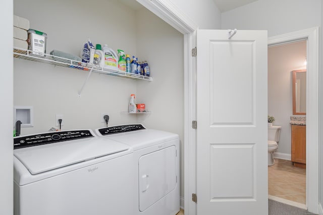 laundry room with washing machine and clothes dryer and tile patterned flooring