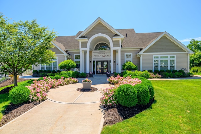 view of front facade featuring a front lawn and french doors