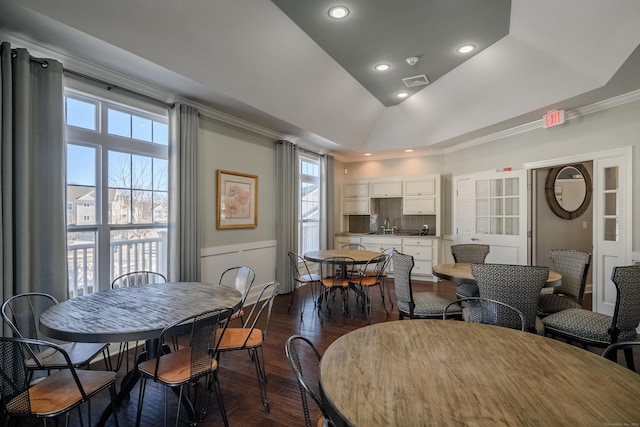 dining area with a raised ceiling, crown molding, dark hardwood / wood-style flooring, and lofted ceiling