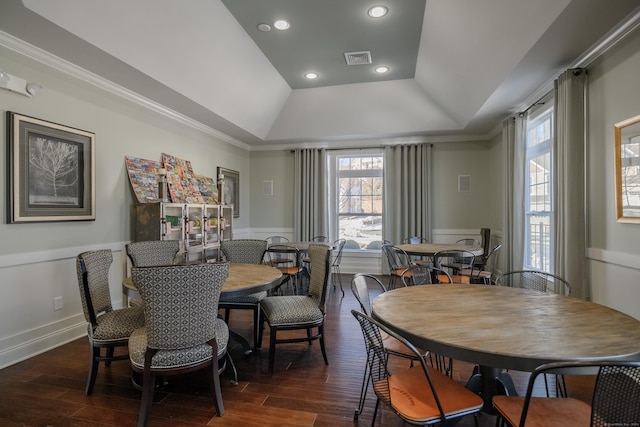 dining room featuring a tray ceiling, dark hardwood / wood-style floors, and ornamental molding