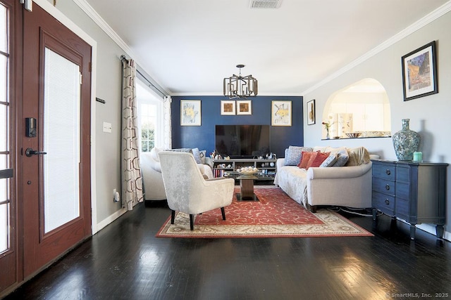 living room featuring dark hardwood / wood-style floors, crown molding, and a chandelier