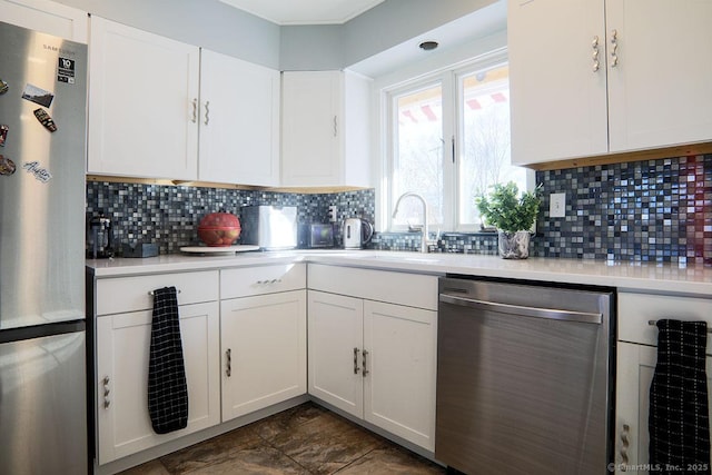 kitchen with white cabinets, backsplash, sink, and stainless steel appliances