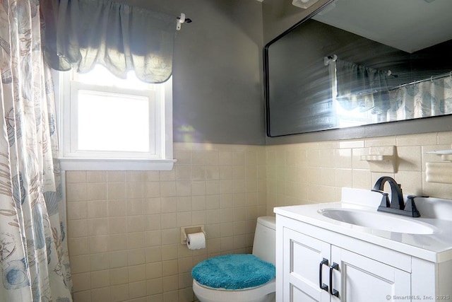 bathroom featuring tile walls, toilet, and vanity