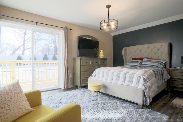 bedroom with dark wood-type flooring, a chandelier, and access to exterior