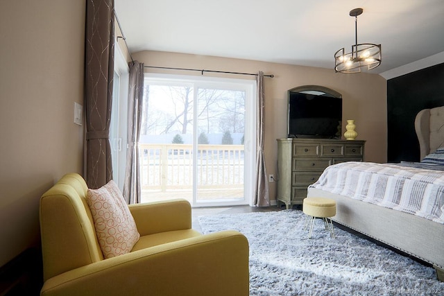 bedroom with access to exterior, a notable chandelier, and vaulted ceiling