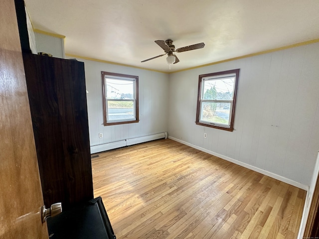 unfurnished room with baseboard heating, ceiling fan, light hardwood / wood-style flooring, and ornamental molding