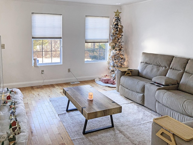 living room with light wood-type flooring and ornamental molding