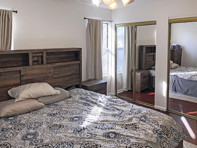 bedroom with ceiling fan with notable chandelier and two closets