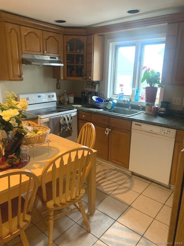 kitchen with light tile patterned flooring, white appliances, and sink