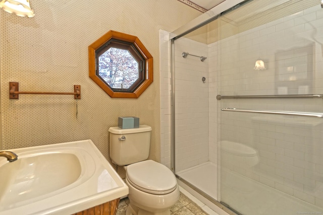 bathroom with an enclosed shower, toilet, sink, and tile patterned floors