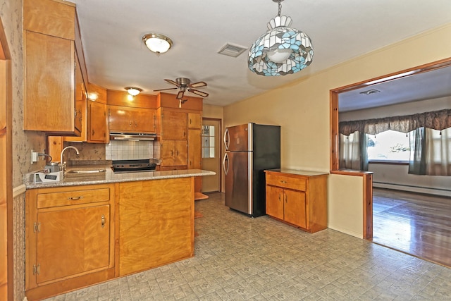 kitchen with backsplash, ceiling fan, sink, stainless steel refrigerator, and hanging light fixtures