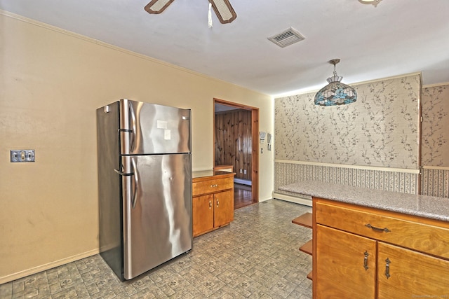 kitchen with crown molding, hanging light fixtures, ceiling fan, baseboard heating, and stainless steel refrigerator