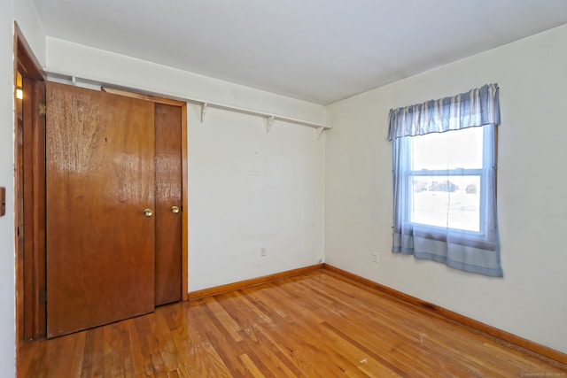 unfurnished bedroom with a closet and hardwood / wood-style floors